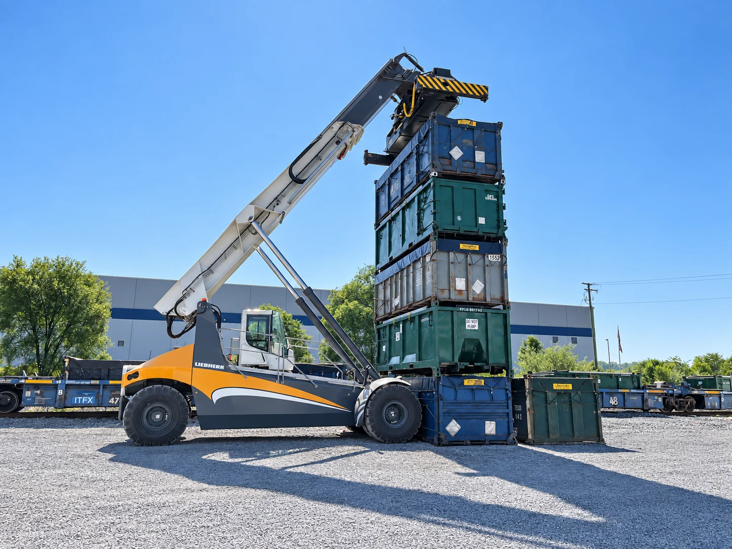 Liebherr reach stacker with raised boom beside stacked intermodal containers